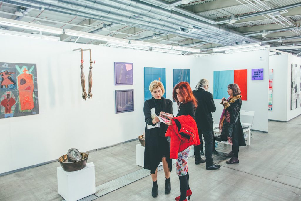 Contemporary, abstract paintings and sculptures at an exhibition space.