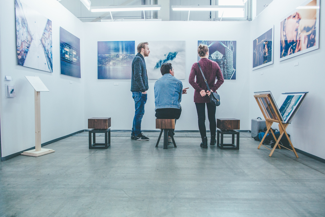 Visitors discussing the merits of large-scale photographies at a trade fair.