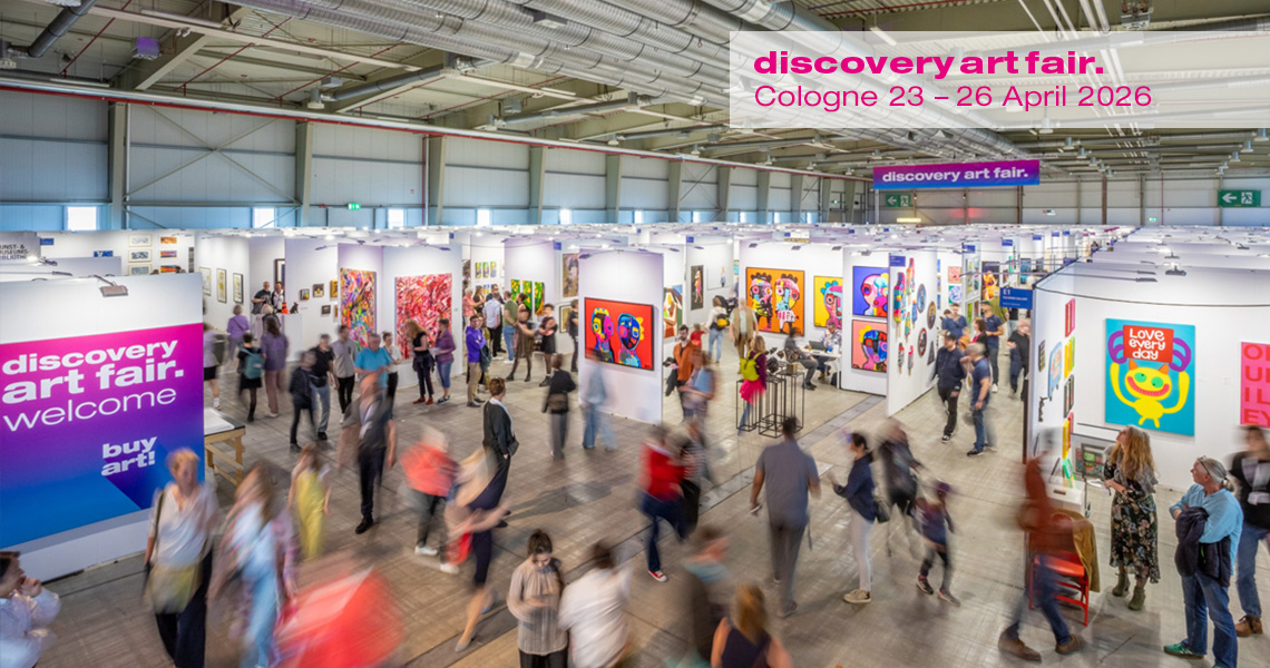 Besucher strömen durch die Gänge der Discovery Art Fair in Köln, umgeben von modernen, farbenfrohen Kunstwerken in Galerieboxen; die Messe zeigt zeitgenössische Kunst von aufstrebenden Künstlern und etablierten Galerien, mit einem Fokus auf Kunstkauf und -vermittlung im lebendigen Kunstmarkt.